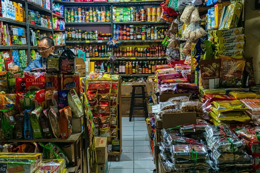 Pedagang lokal di pasar tradisional Indonesia dengan berbagai produk UMKM di kiosnya